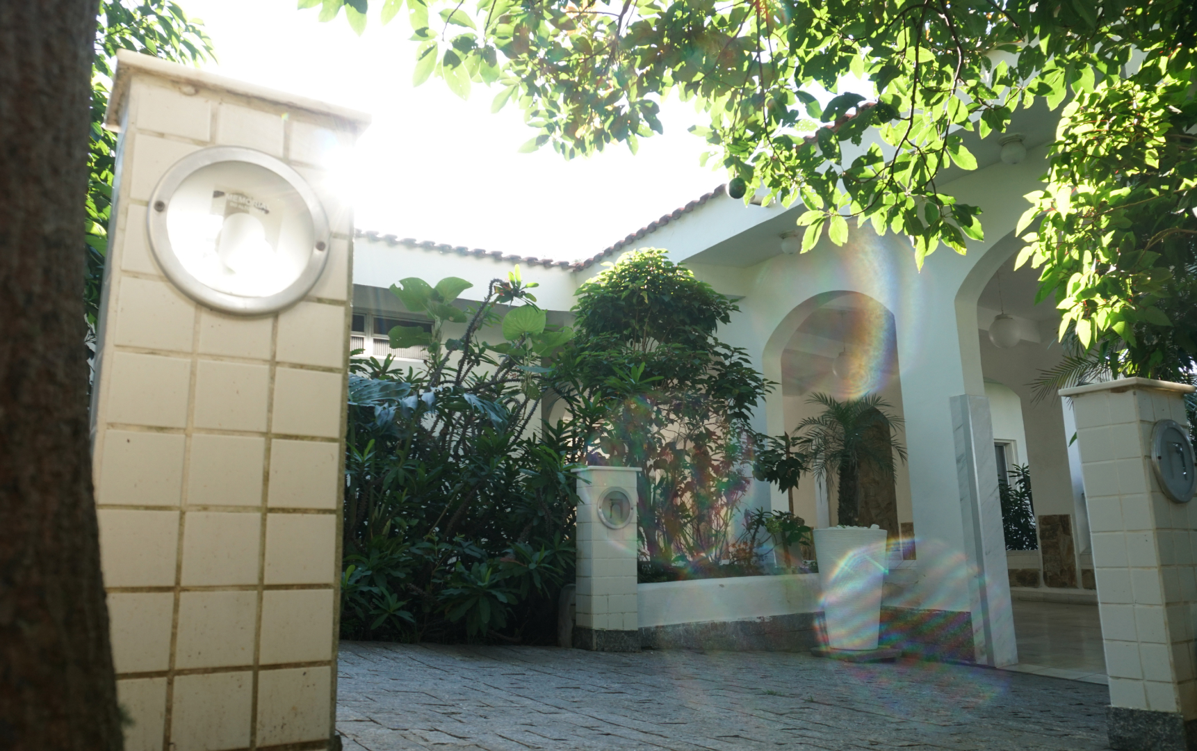 Hall de entrada com pilar revestido e jardim ao fundo