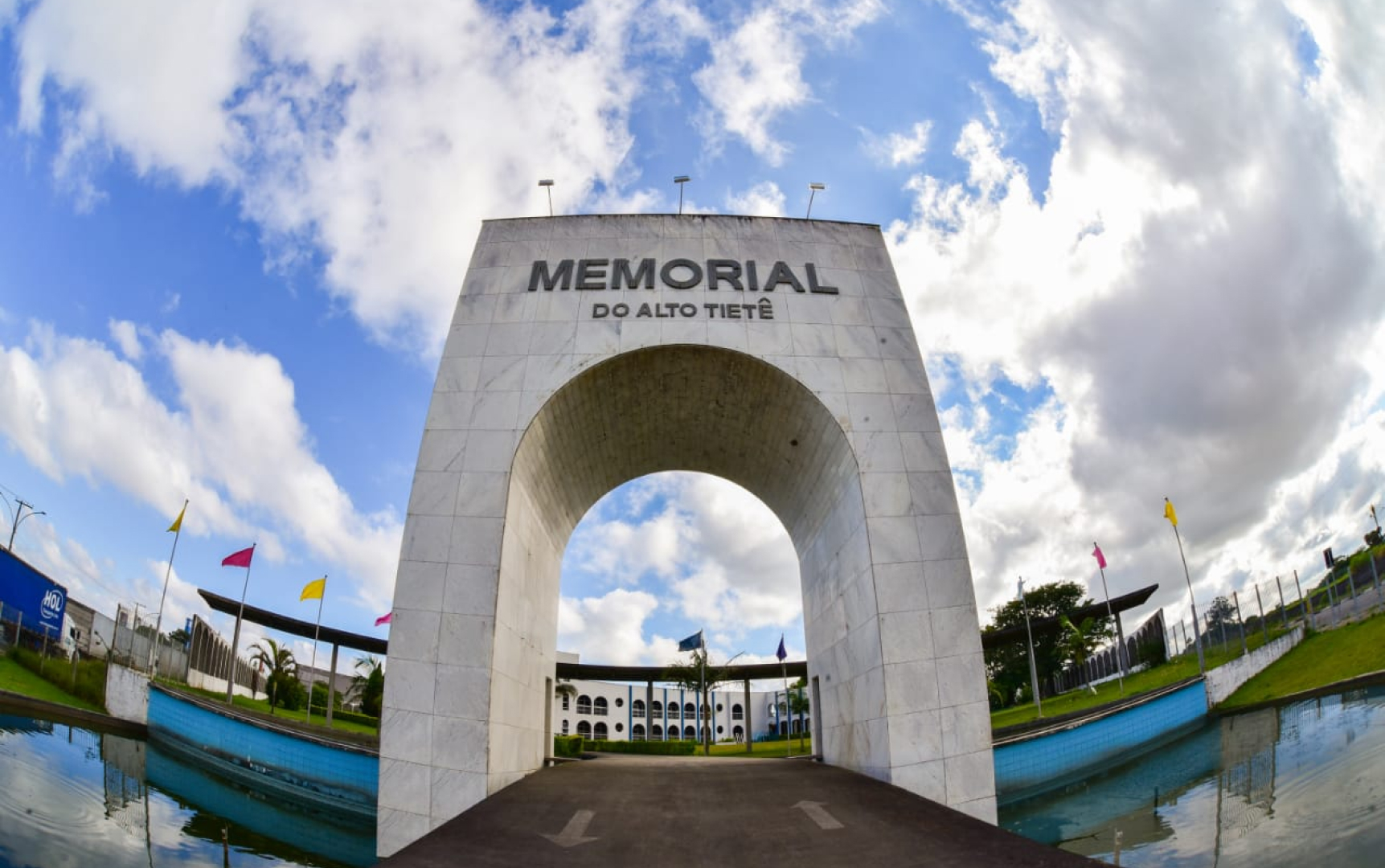 Pórtico de concreto com o nome do Memorial sobre o espelho d’água